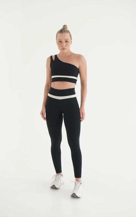 Woman wearing black two-piece athleisure set with high-waist leggings and sports bra