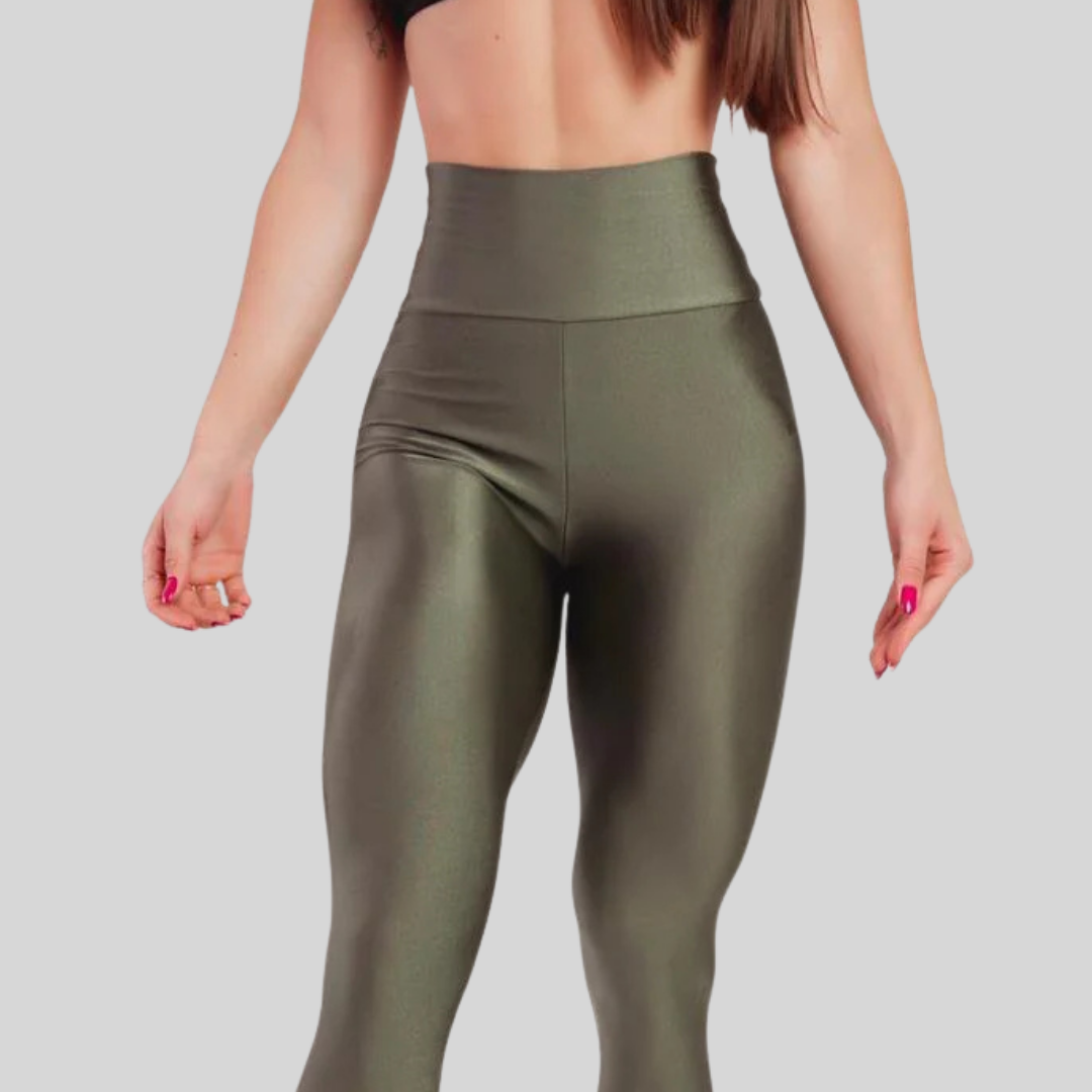 Person wearing olive green leggings on a plain background