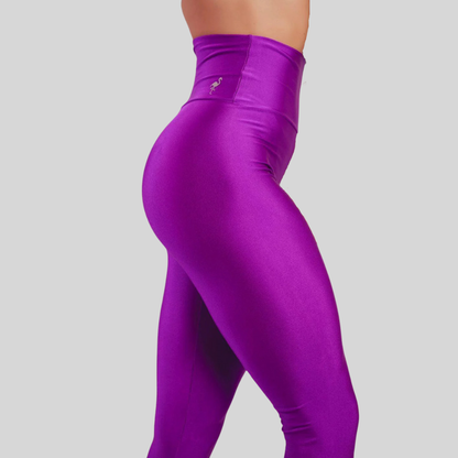 Purple leggings worn by a person on a gray background